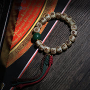 Detail view of Carved Symbol Bead Buddhist Bracelet with Green Accent (3 of 6)