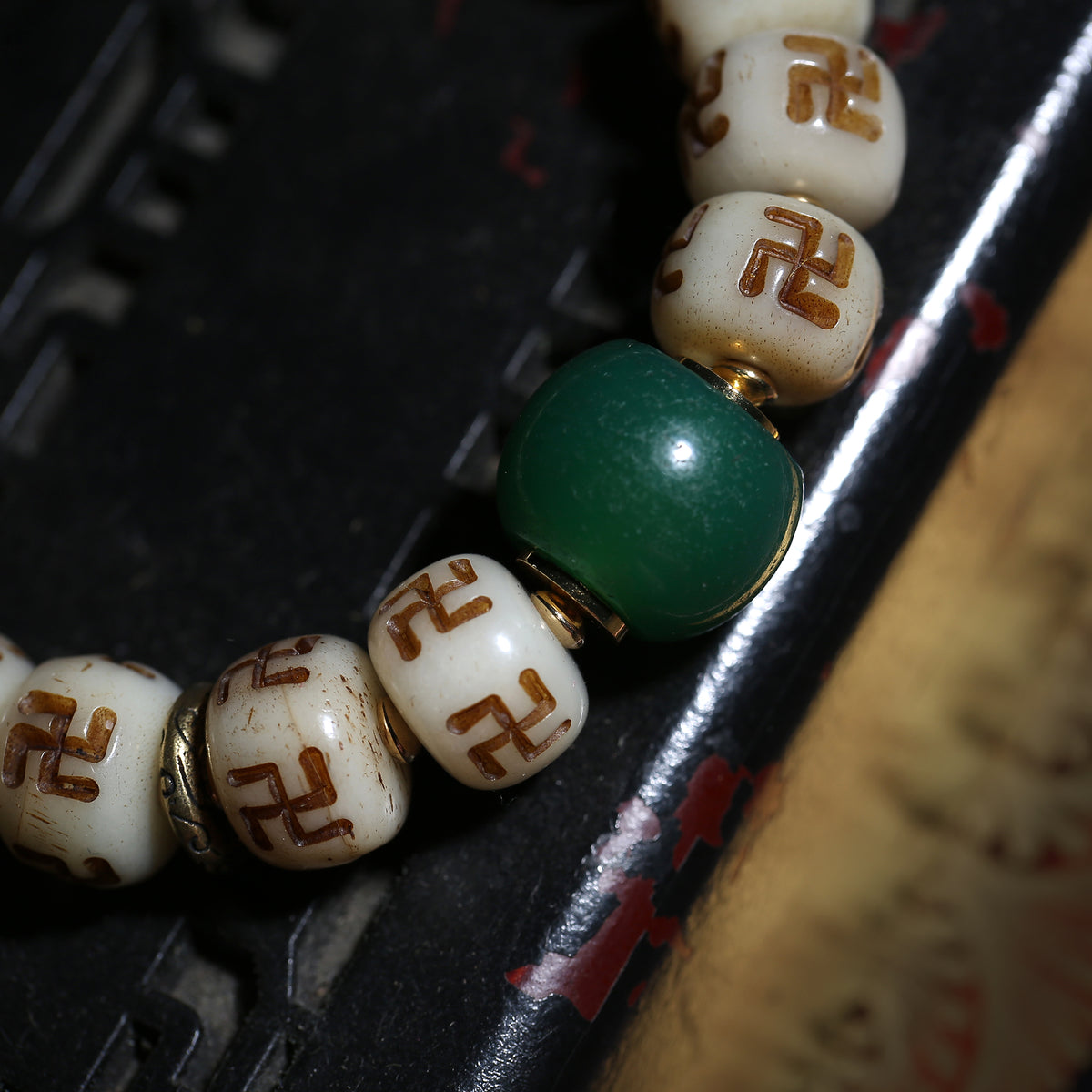 Detail view of Carved Symbol Bead Buddhist Bracelet with Green Accent (5 of 6)